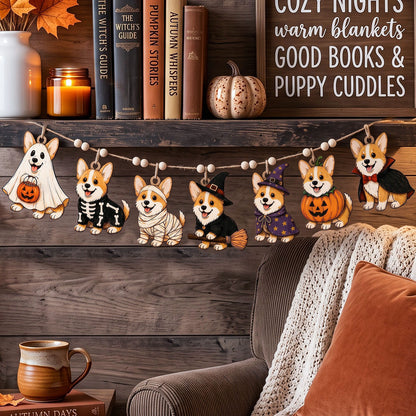 Halloween-themed corgi dog garland hanging on a wooden shelf above a cozy armchair, surrounded by fall decor including books, a candle, a small pumpkin, and a blanket.