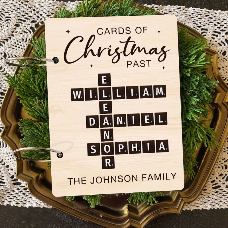 A personalized card holder with 'Cards of Christmas Past' text, featuring a Scrabble-style game board design, and personalized with names and the Johnson family crest.