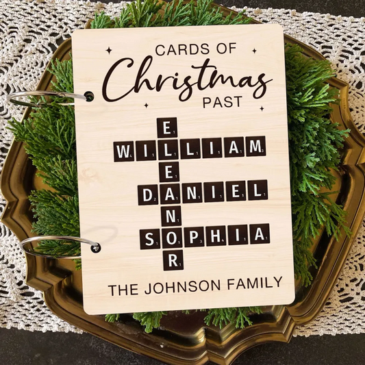 A personalized card holder with 'Cards of Christmas Past' text, featuring a Scrabble-style game board design, and personalized with names and the Johnson family crest.