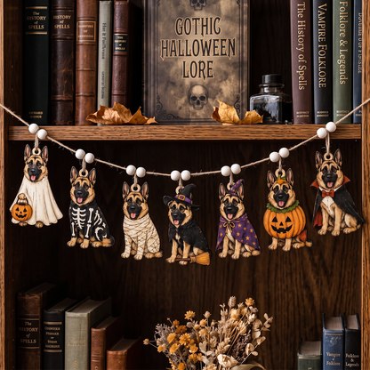 A Halloween-themed wooden garland featuring six German Shepherd figures dressed in different costumes, hanging on a string in front of a wooden bookshelf decorated with books and autumn leaves.