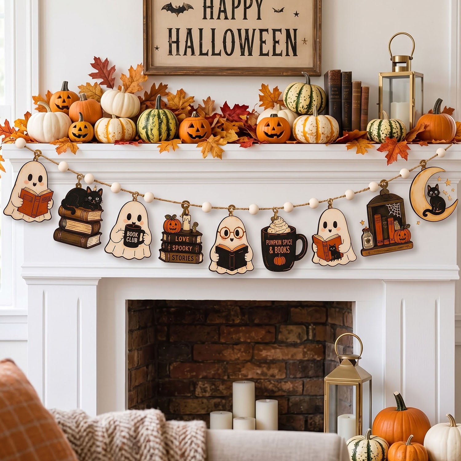 A cozy Halloween-themed fireplace mantel decorated with pumpkins, fall leaves, a lantern, and a wooden 'Happy Halloween' sign. A string banner garland hangs across the mantel, featuring cute ghost and mug-shaped wooden cutouts with spooky designs like 'Read a Book', 'Love a Ghost', and 'Spooky Night & Books'.