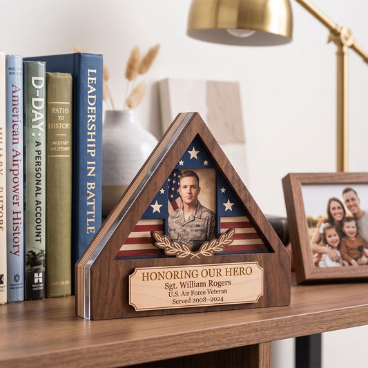 A triangular wooden memorial plaque displayed on a shelf, featuring a photo of a U.S.