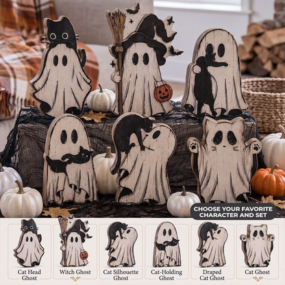 A set of carved wooden Halloween ghost decorations displayed on a black fabric stand, surrounded by small pumpkins. The top row shows five main ghost designs: Cat Head, Witch, Cat Silhouette, Cat Holding Pumpkin, and Draped.